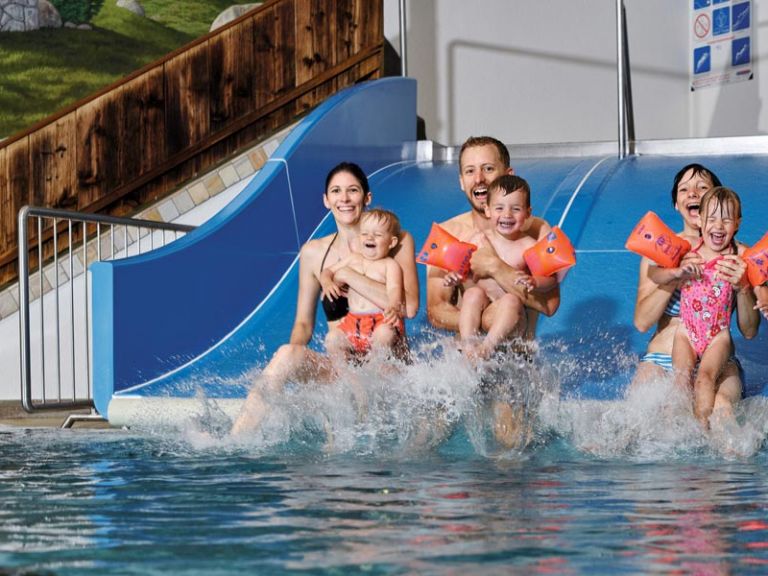 Familie beim Rutschen im Spaßbad
