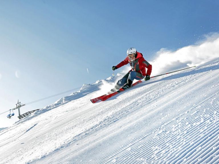 Skier descending on prepared piste